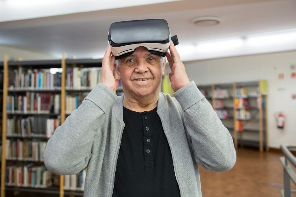 man in gray cardigan wearing virtual reality goggles